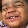 Ameera is registered to the contest to win money with this photo: baby, smiling, closeup, face, joyful, child, happy, teeth, patterned_clothing, infant, skin, portrait, cute, expression, young, person, head, cheerful, tongue, mouth