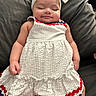 baby, child, sleeping, headband, dress, white_dress, red_trim, blue_trim, couch, cushion, indoor, peaceful, cute, infant, person, portrait, smile, relaxed, hand, legs