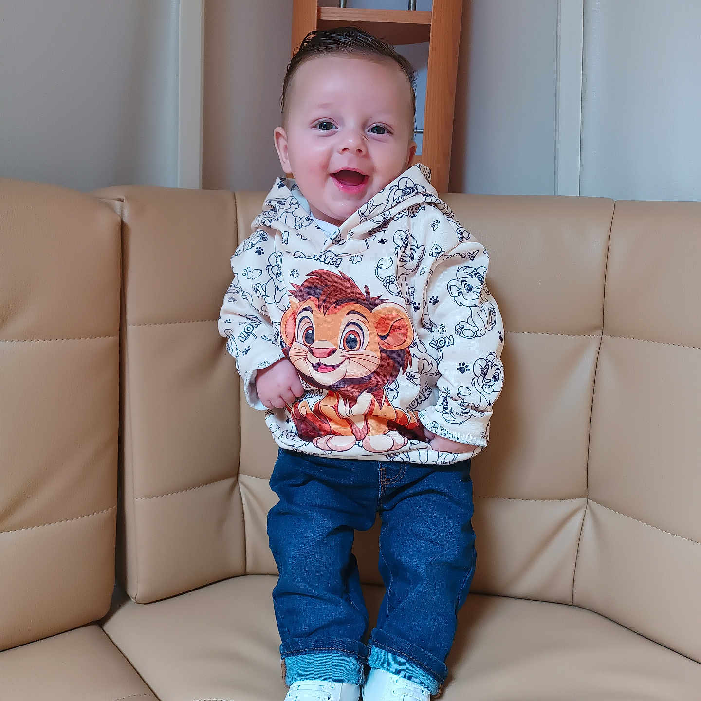 Djeeroy participe au concours pour gagner de l'argent avec cette photo : cartoon, casual_clothing, child, couch, furniture, happy, hoodie, indoor, jeans, leather, lion, person, portrait, shelf, sitting_area, smiling, standing, toddler, white_shoes, wood