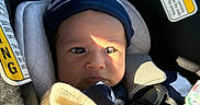Sylas joined the competition — help win amazing prizes! baby, infant, child, car_seat, vehicle, safety_harness, beanie, blanket, bundled_up, portrait, face, eyes, sunlight, indoor, travel, passenger, cozy, seated, automotive, warning_label