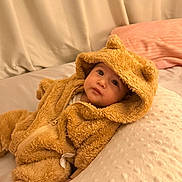 Sylas is registered to the contest to win money with this photo: baby, bear_hood, bed, bedding, bedroom, blanket, child, cozy, face, fuzzy_clothing, hood, indoor, infant, lying_down, onesie, pillow, portrait, sitting, teddy_bear, wide_eyes