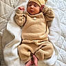 newborn, baby, infant, portrait, sleeping, knitted_outfit, beanie, brown_clothing, blanket, bed, cozy, cute, peaceful, lying_down, indoors, soft_lighting, natural_light, tiny_feet, hands, textile