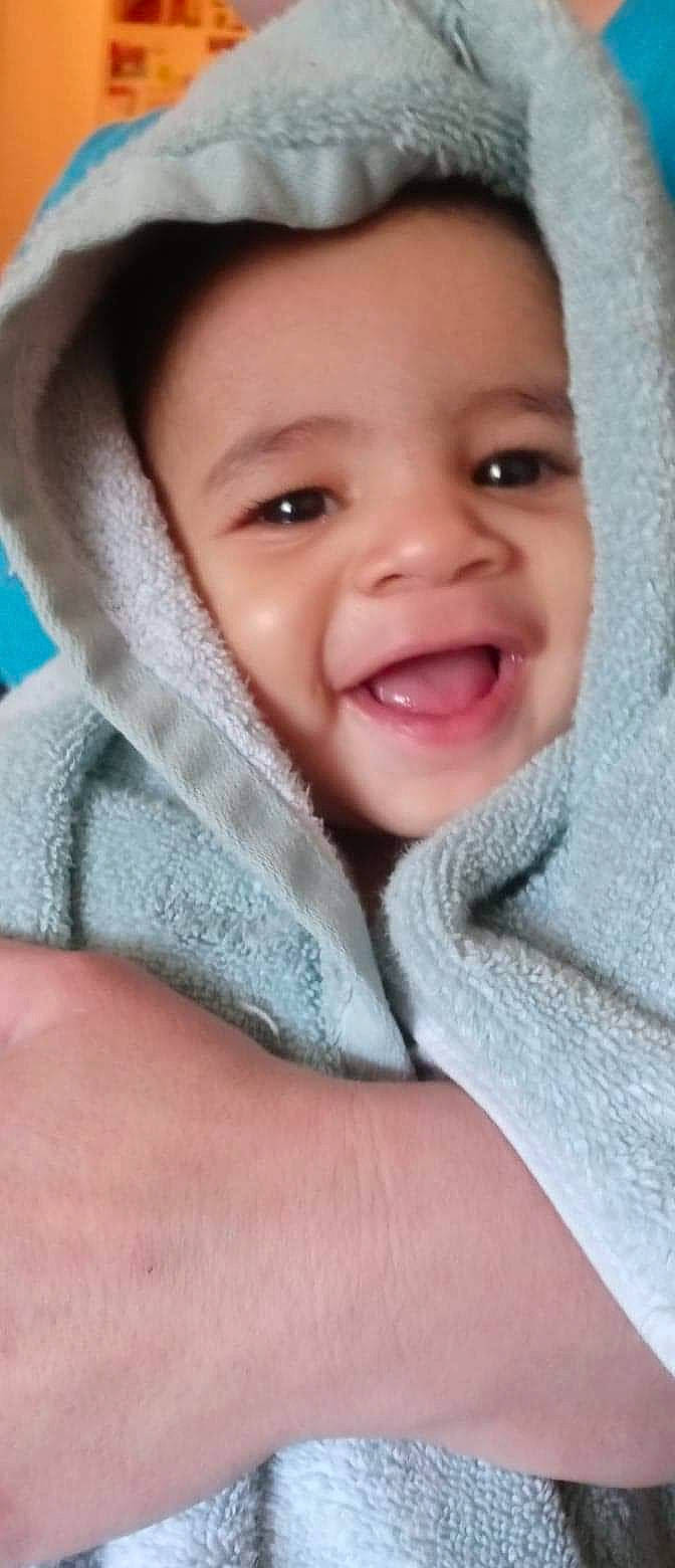 Moses is registered to the contest to win money with this photo: baby, baby_products, cheek, child, comfort, eyelash, fun, gesture, happy, iris, laugh, linens, lip, mouth, nose, person, skin, sleeve, smile, toddler