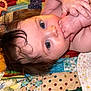 baby, infant, child, face, hand, skin, hair, blue_eyes, blanket, quilt, pattern, colorful, lying_down, portrait, cute, young, baby_hands, indoors, closeup, sleepwear