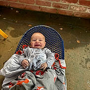 Levi is registered to the contest to win money with this photo: baby, blanket, brick, chair, city, clothing, face, furniture, happy, head, newborn, pants, person, photography, portrait, road, sitting, smile, street, urban