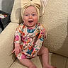 Eleanor joined the competition — help win amazing prizes! baby, child, infant, smiling, happy, portrait, sitting, armchair, cushion, floral_dress, headband, bow, colorful_clothing, indoors, home, furniture, face, eyes, hands, legs