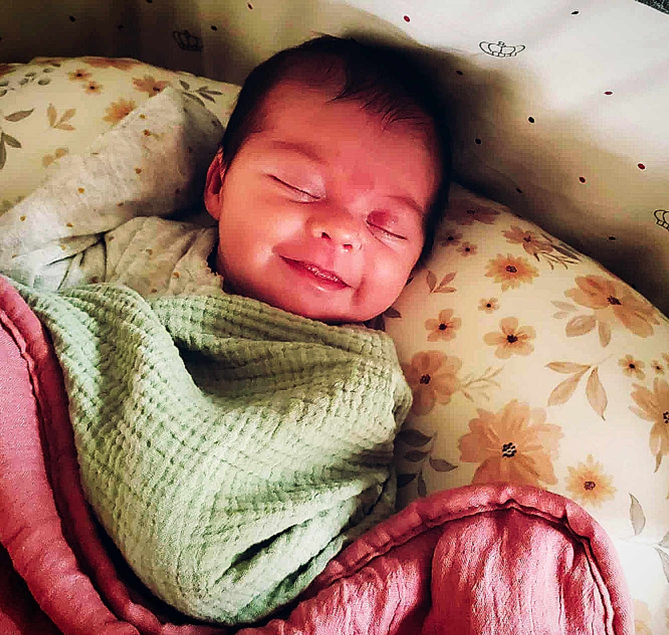 Lillian joined the competition — help win amazing prizes! baby, sleeping, smiling, blanket, quilt, pillow, floral_pattern, infant, wrapped, cozy, face, peaceful, indoors, cute, child, resting, soft_lighting, head, person, portrait
