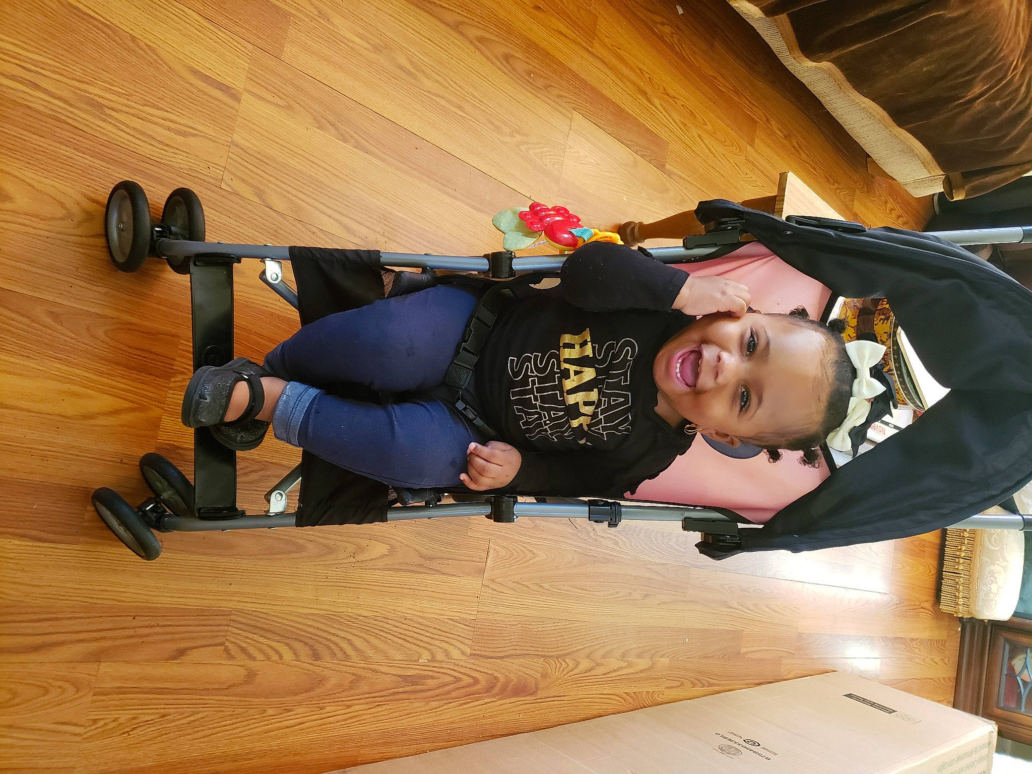 Phoenix is registered to the contest to win money with this photo: child, elbow, flooring, fun, hardwood, helmet, human_leg, knee, person, personal_protective_equipment, recreation, rolling, sitting, sleeve, sportswear, thigh, toddler, varnish, wood, wood_flooring