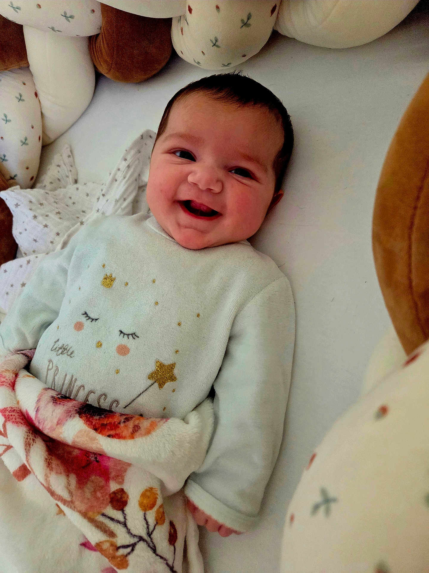 Thaïs participe au concours pour gagner de l'argent avec cette photo : baby, smiling, blanket, soft_toys, infant, cozy, cute, face, child, bed, clothing, portrait, happy, indoors, person, sleeping_area, wrapped, cute_outfit, warm, lying_down