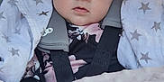 Thaïs a rejoint le concours — aidez-le/la à gagner de superbes lots ! baby, infant, car_seat, blanket, star_pattern, soft_light, face, child, wrapped, warm, cozy, seated, clothing, pink, gray, hands, portrait, indoor, expression, cute