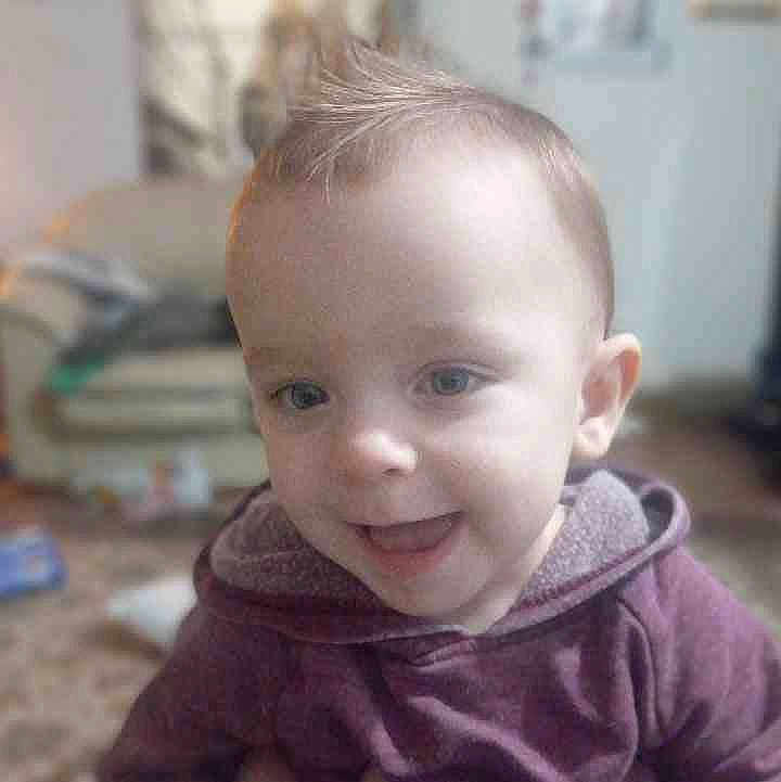 Henry joined the competition — help win amazing prizes! toddler, child, face, smiling, tongue_out, hoodie, indoor, living_room, hair, blue_eyes, person, cute, young_child, cozy, portrait, sitting, carpet, blurred_background, happy, casual_clothing