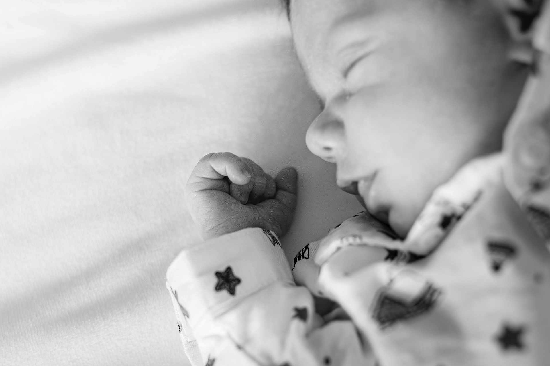 Victor participe au concours pour gagner de l'argent avec cette photo : baby, sleeping, black_and_white, close_up, hand, face, onesie, star_pattern, infant, peaceful, soft, portrait, child, resting, cute, newborn, cozy, sleep, monochrome, quiet