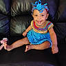 baby, child, infant, smiling, sitting, portrait, colorful_clothing, crocheted_outfit, blue_hat, yarn, leather_chair, indoor, happy, grinning, barefoot, dress, fashion, playful, bright_colors, photography
