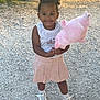 Kyara participe au concours pour gagner de l'argent avec cette photo : casual_clothing, child, cotton_candy, curly_hair, daytime, food, girl, gravel, happy, outdoor, pink, playful, portrait, skirt, smiling, snack, sneakers, standing, sunlight, white_top