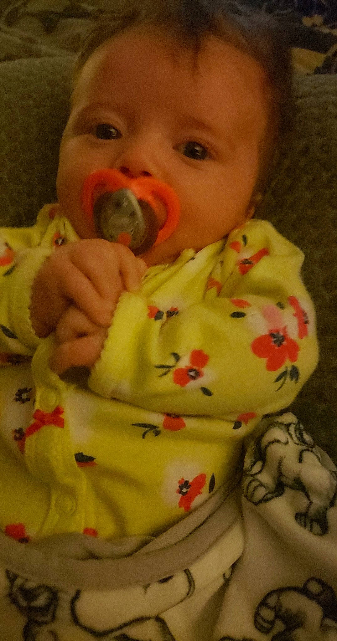 Andrea is registered to the contest to win money with this photo: baby, baby_products, baby_toddler_clothing, cheek, child, comfort, dress, facial_expression, finger, hand, human_body, linens, lip, mouth, neck, nose, person, sitting, skin, sleeve