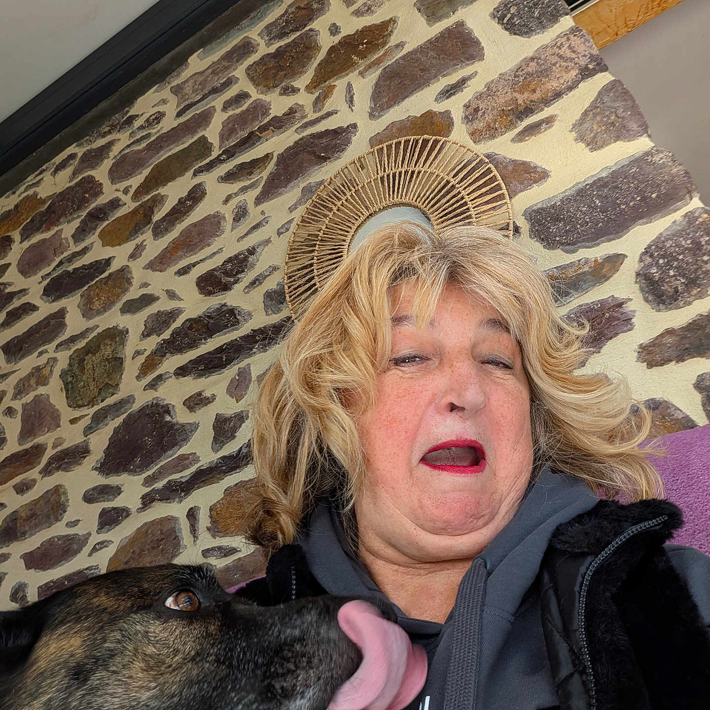 Nauny participe au concours pour gagner de l'argent avec cette photo : blonde_hair, casual_clothing, closeup, companion, decor, dog, expression, funny_face, hoodie, humor, interaction, licking, outdoor, pet, portrait, seated, selfie, stone_wall, tongue_out, woman