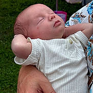 Ryder is registered to the contest to win money with this photo: baby, sleeping, infant, hands, grass, white_clothing, person, arm, peaceful, outdoor, closeup, skin, portrait, newborn, relaxing, human, soft_light, casual, resting, cute