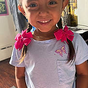Remie joined the competition — help win amazing prizes! child, girl, smile, braids, pink_bows, white_shirt, butterfly, indoor, portrait, happy, young, cute, earrings, necklace, standing, wood_floor, casual_clothing, home, natural_light, person