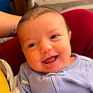 Delilah joined the competition — help win amazing prizes! baby, bee_pattern, blanket, child, cushion, cute, expression, face, happy, head, indoors, infant, onesie, person, portrait, purple_clothing, red_cushion, smiling, yellow_blanket, young