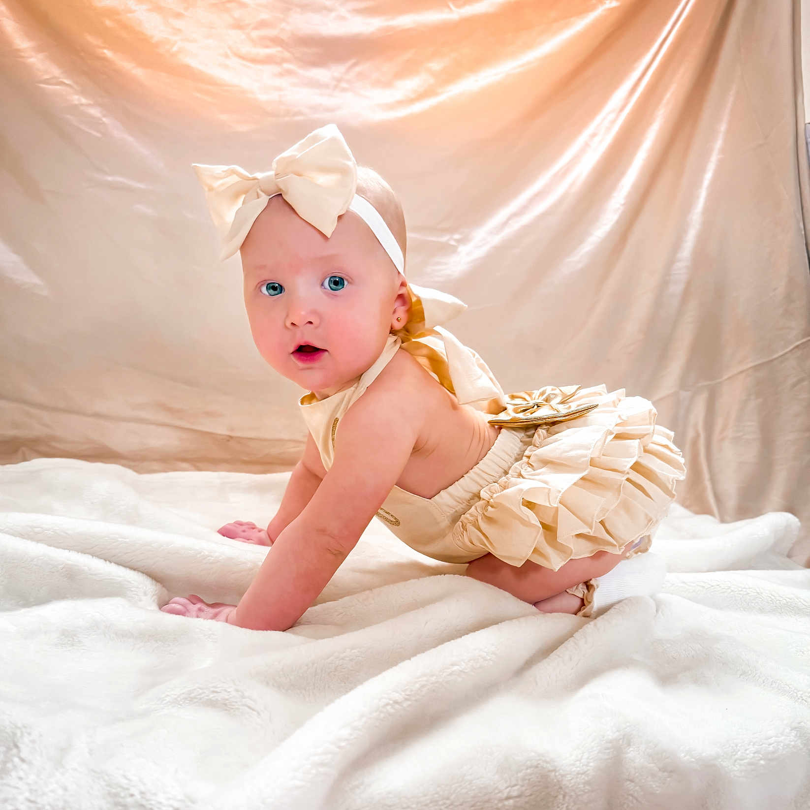 Wrenley joined the competition — help win amazing prizes! baby, blanket, blue_eyes, bow, child, clothing, crawling, cream_color, curious, cute, fabric, girl, headband, indoor, infant, portrait, ruffles, satin_background, soft_texture, toddler