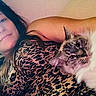 woman, cat, leopard_print, animal, pet, portrait, indoor, relaxing, feline, long_hair, smile, face, fur, cozy, comfort, resting, casual, human, closeup, laying_down