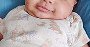 Elijah joined the competition — help win amazing prizes! baby, infant, child, smiling, portrait, closeup, face, eyes, indoors, cushion, blue_background, blanket, onesie, clothing, sitting, lying_down, happy, cute, head, photography