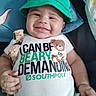 baby, child, infant, smiling, happy, portrait, green_hat, clothing, teddy_bear, onesie, textile, bed, blanket, indoors, close_up, face, hands, arms, seated, cute