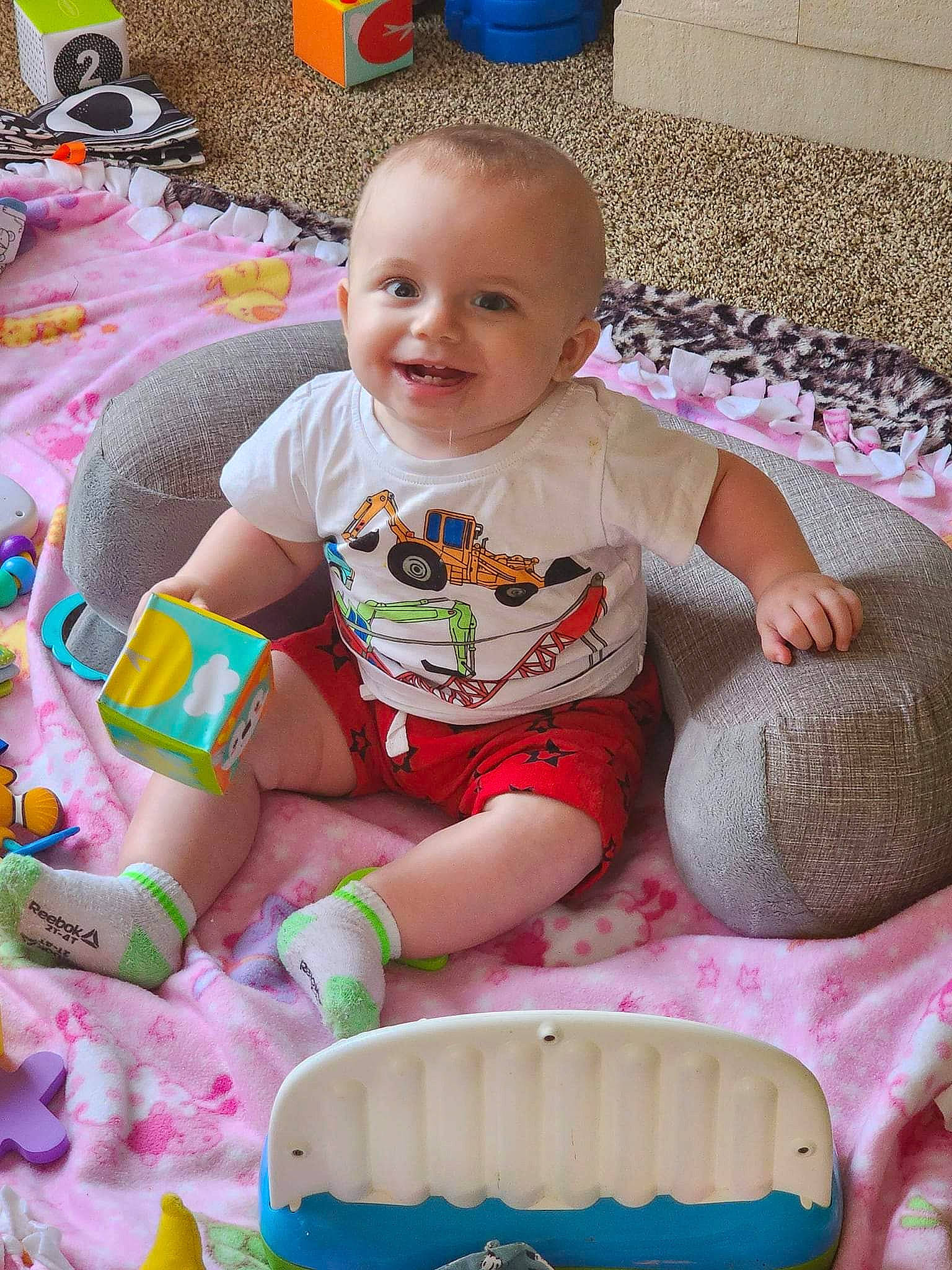 Sawyer Ryan joined the competition — help win amazing prizes! baby, baby_playing_with_toys, baby_products, baby_toddler_clothing, ball, cheek, child, facial_expression, flooring, fun, happy, joy, leisure, person, pink, play, product, sitting, skin, smile