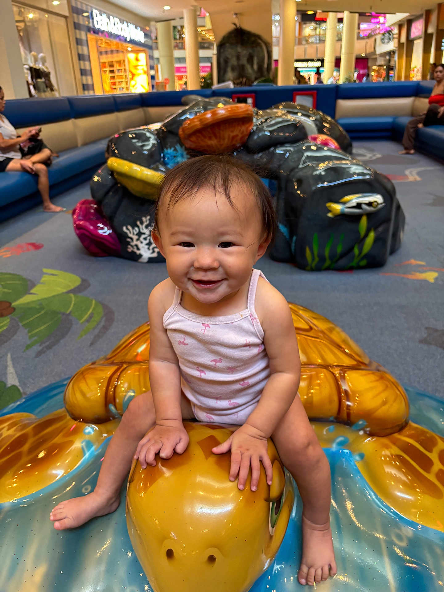 Kaili joined the competition — help win amazing prizes! toddler, child, smiling, playground, indoor, mall, toy, sculpture, turtle, colorful, people, seating, floor, clothing, happy, person, play, fun, cute, baby