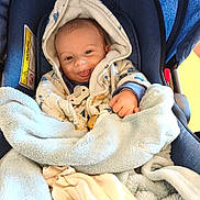 Gennaro a rejoint le concours — aidez-le/la à gagner de superbes lots ! baby, car_seat, blanket, hoodie, smile, tongue_out, infant, clothing, blue, comfort, cute, bundle, fabric, seat, child, face, hand, indoor, soft, warm
