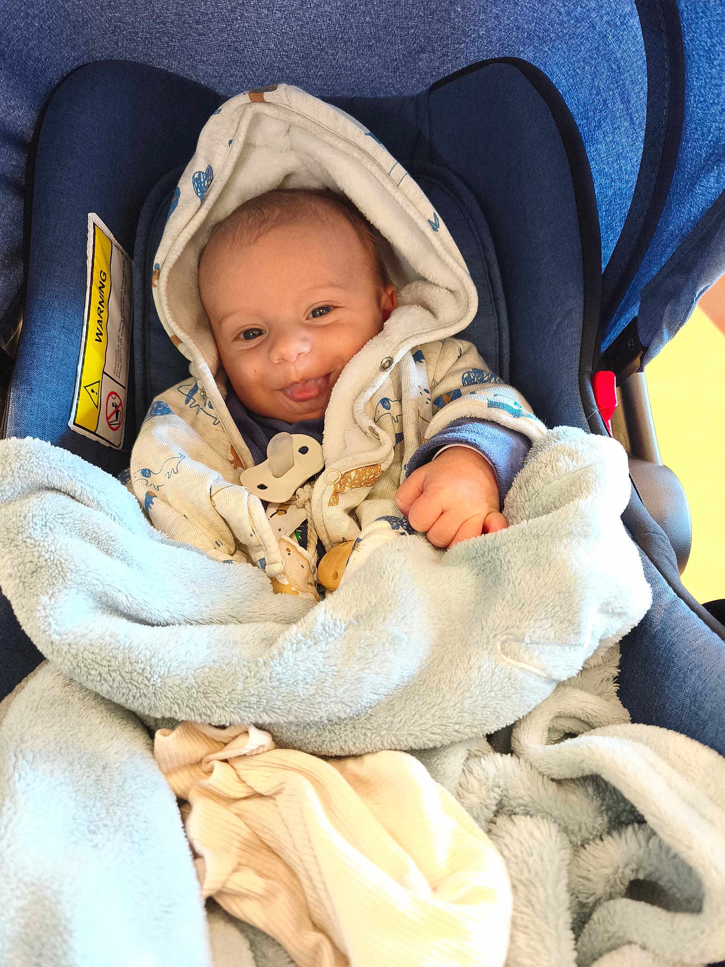 Gennaro a rejoint le concours — aidez-le/la à gagner de superbes lots ! baby, car_seat, blanket, hoodie, smile, tongue_out, infant, clothing, blue, comfort, cute, bundle, fabric, seat, child, face, hand, indoor, soft, warm