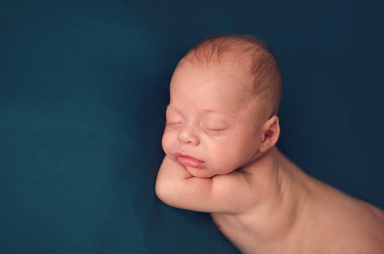 Tate is registered to the contest to win money with this photo: cheek, child, close_up, hand, infant, nose, person