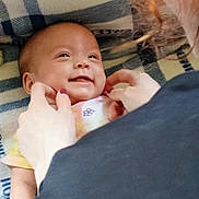 Penelope joined the competition — help win amazing prizes! baby, smile, person, hands, blanket, plaid, cozy, infant, face, child, gentle, touch, joyful, happy, closeup, human, cute, comfort, interaction, soft