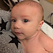 Cyrus is registered to the contest to win money with this photo: baby, infant, face, skin, eyes, expression, closeup, portrait, newborn, person, child, cute, soft, texture, fabric, pattern, black_stars, resting, indoors, warm