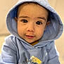 baby, child, hoodie, blue_clothing, face, eyes, portrait, cute, infant, young_child, sitting, indoors, soft_lighting, casual_clothing, smiling, person, closeup, headwear, warm_clothing, adorable