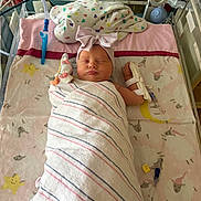 Addison is registered to the contest to win money with this photo: newborn, baby, hospital, bassinet, blanket, headband, bow, sleeping, medical_tubes, monitor, sheet, pattern, sheep, star, pink, cute, infant, swaddled, child, nursery