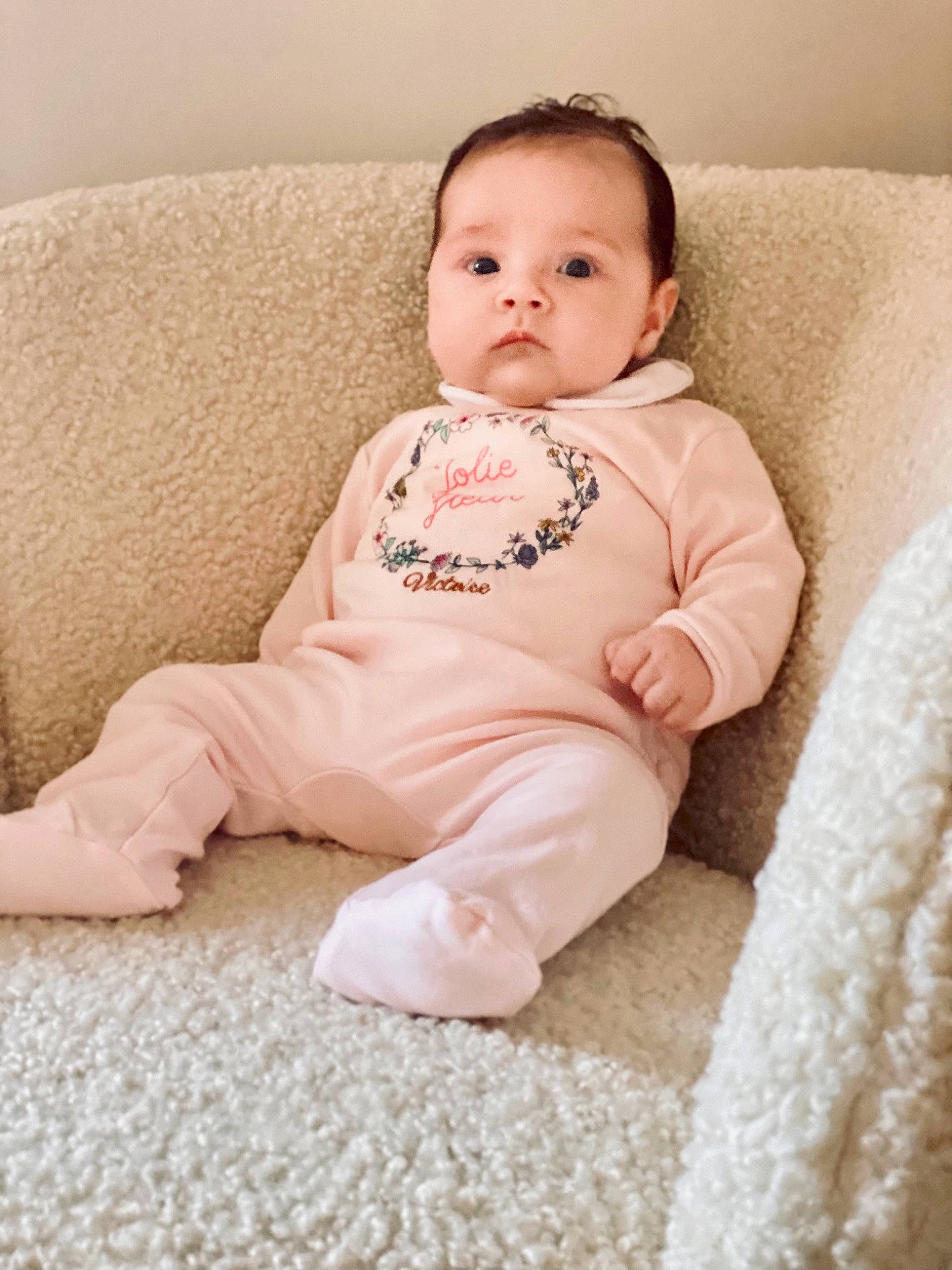 Victoire a rejoint le concours — aidez-le/la à gagner de superbes lots ! baby, baby_toddler_clothing, cheek, child, comfort, couch, eye, face, flooring, happy, iris, linens, lip, neck, person, pink, sitting, skin, sleeve, toddler