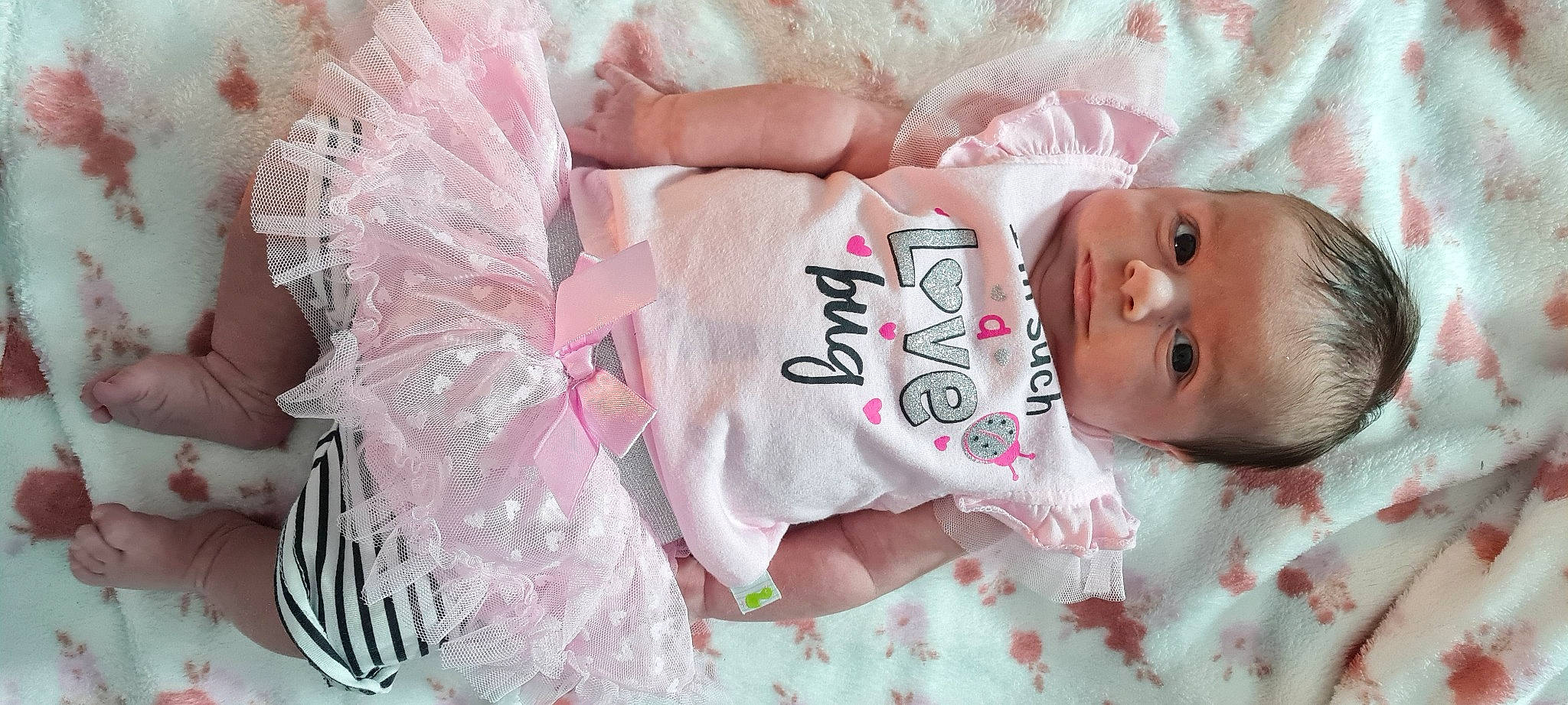 Ariyah is registered to the contest to win money with this photo: baby, baby_toddler_clothing, child, comfort_food, eyelash, flesh, font, happy, linens, magenta, nail, pattern, peach, person, pink, product, sleeve, textile, toddler