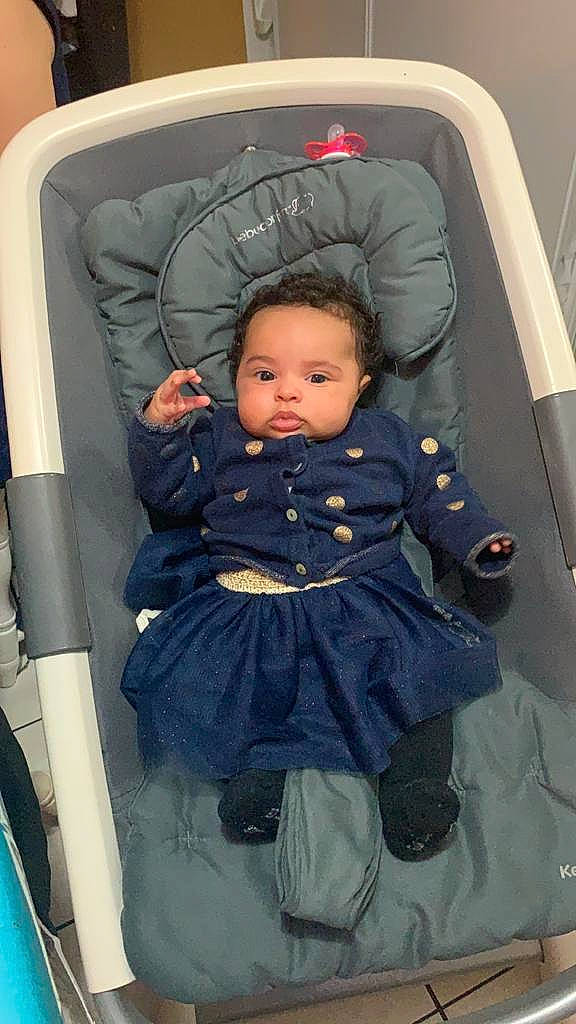 Alima Macogno a rejoint le concours — aidez-le/la à gagner de superbes lots ! auto_part, baby, baby_carriage, baby_products, baby_safety, baby_toddler_clothing, car_seat, chair, cheek, child, comfort, facial_expression, fun, hairstyle, mammal, outerwear, person, room, sitting, toddler