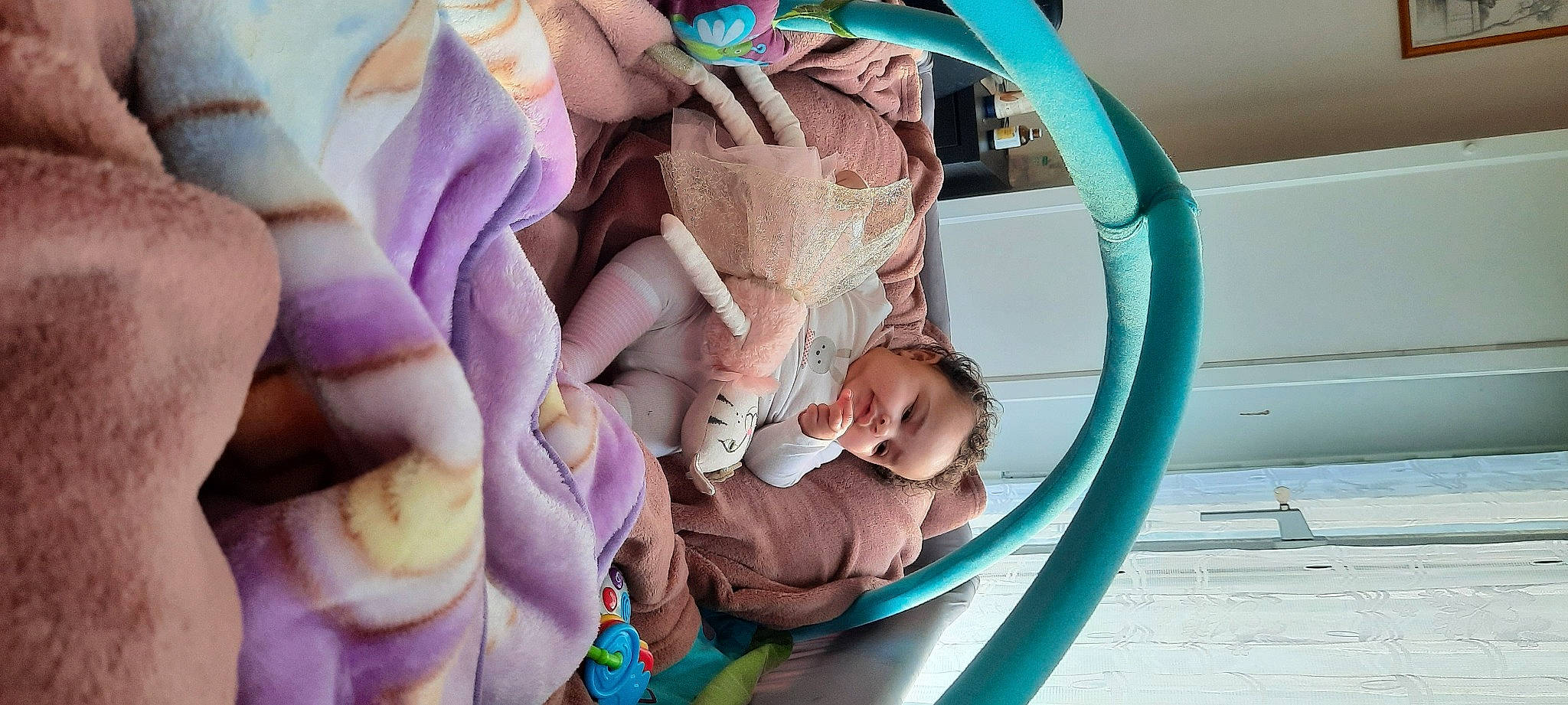 Alima Macogno participe au concours pour gagner de l'argent avec cette photo : baby, baby_carriage, baby_products, baby_toddler_clothing, cheek, child, comfort, eye, grass, green, head, human_body, linens, magenta, person, pink, purple, room, sitting, skin