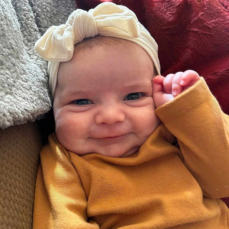 Elly is registered to the contest to win money with this photo: baby, babylaughing, blanket, bonnet, clothing, cushion, face, happy, hat, head, homedecor, newborn, person, photography, portrait, quilt, smile, towel