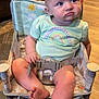 baby, child, infant, sitting, chair, pastel_clothing, rainbow_design, indoor, wood_floor, curious_expression, pouting, baby_seat, soft_lighting, toddler, foot, hand, face, person, cute, young