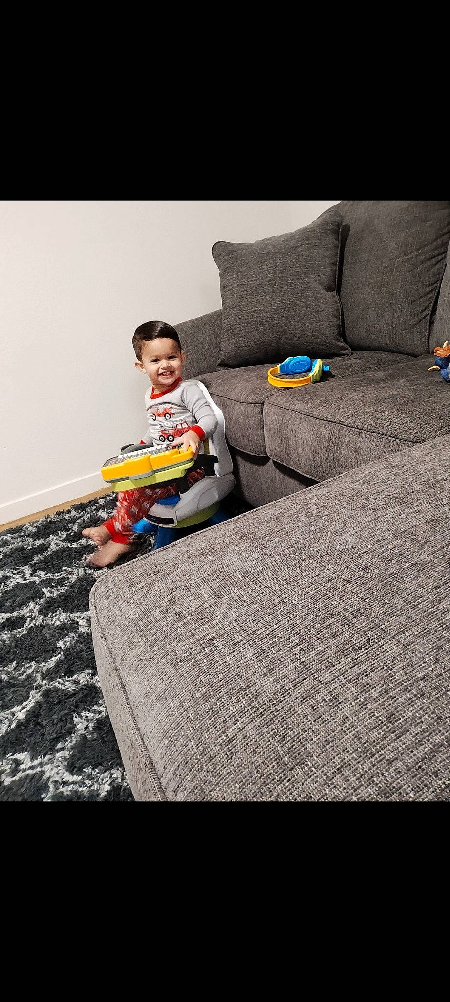 Alijah is registered to the contest to win money with this photo: asphalt, child, comfort, couch, floor, flooring, fun, grass, grey, joy, leisure, linens, person, play, recreation, road_surface, room, sitting, smile, soil