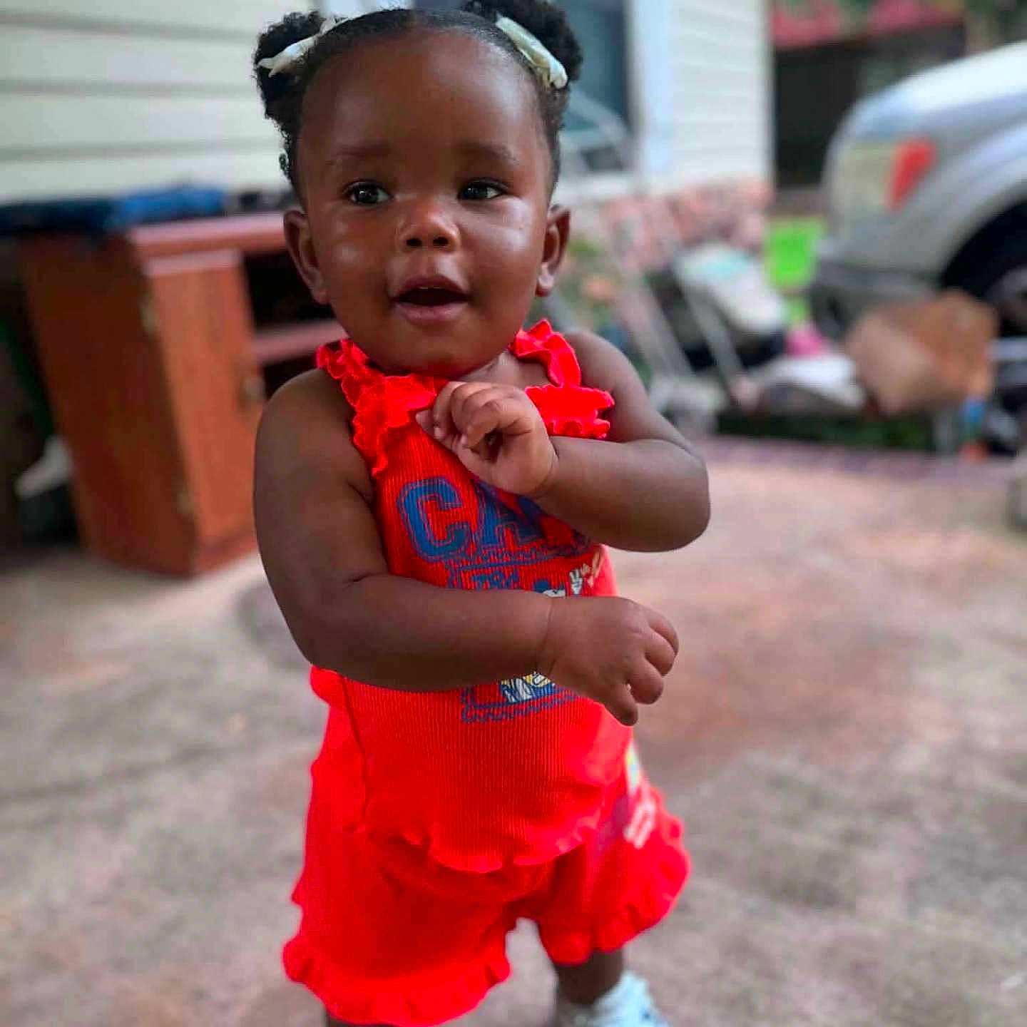Solai joined the competition — help win amazing prizes! building, car, casual, child, concrete_floor, cute, daytime, fashion, hair_puffs, outdoor, person, porch, portrait, red_clothing, smiling, sneakers, standing, toddler, window, young_child