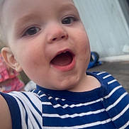 Jason is registered to the contest to win money with this photo: toddler, child, striped_shirt, blue, white, outdoor, door, wooden_floor, happy, smiling, face, person, casual_clothing, expression, young_child, closeup, daylight, curious, small_child, playful