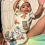 Emani joined the competition — help win amazing prizes! baby, bed, blanket, child, clothing, colorful, cozy, cute, indoors, infant, lying_down, pajamas, patterned_clothing, person, quilt, raised_arms, sleepwear, smiling, sock, soft_texture
