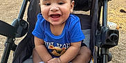 Emani joined the competition — help win amazing prizes! baby, blue_shirt, child, clothing, cute, daylight, expression, feet, happy, infant, nature, outdoor, person, playful, seat, sitting, smile, sneakers, stroller, young_child