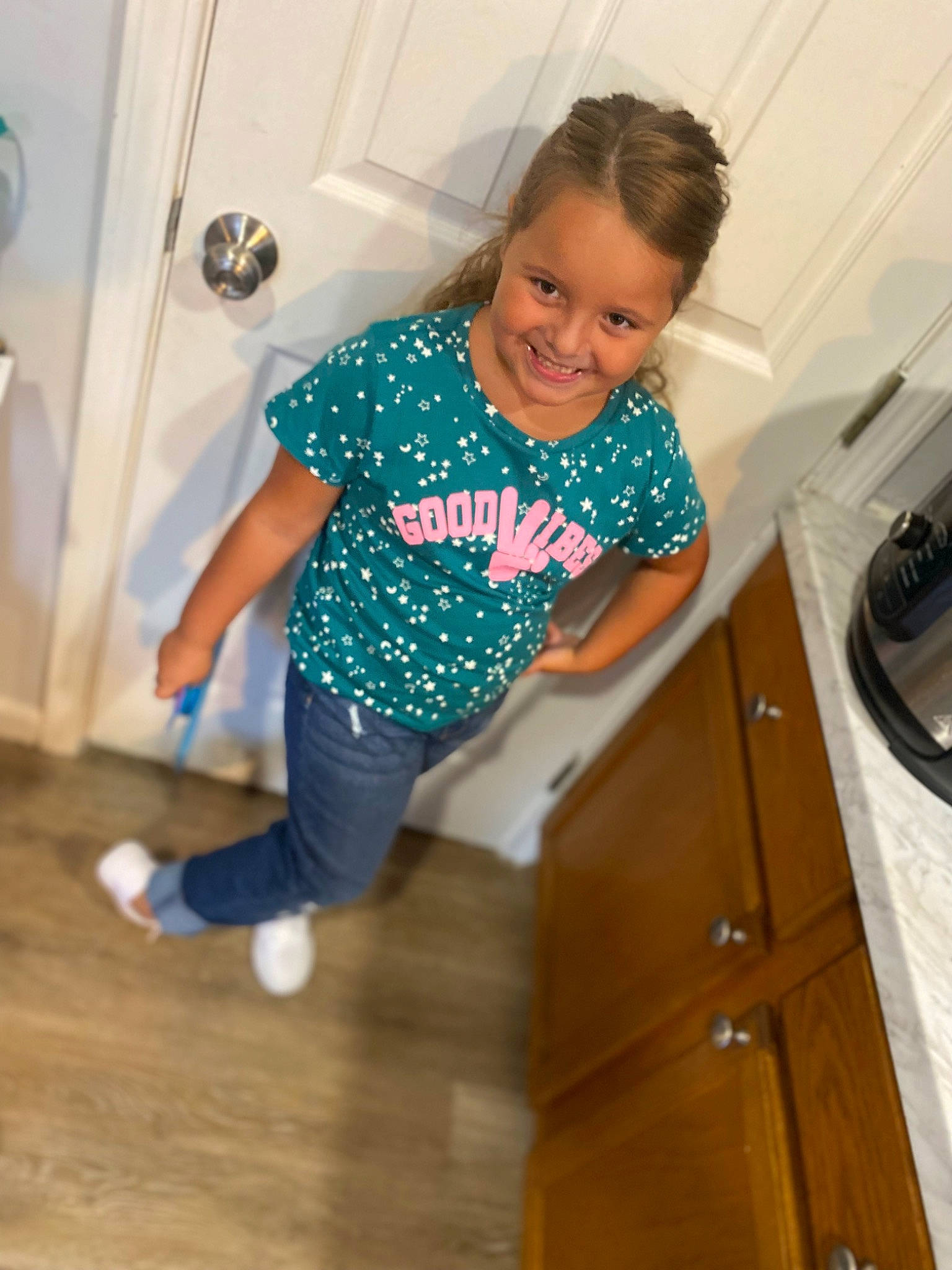 Gracie-ann joined the competition — help win amazing prizes! baby_toddler_clothing, cabinetry, cooktop, floor, flooring, fun, gas_stove, happy, hardwood, joy, kitchen_stove, knee, person, room, sleeve, smile, standing, stove, t_shirt, toddler