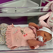 Pennie-Mae joined the competition — help win amazing prizes! newborn, baby, hospital, bassinet, pink, headband, pacifier, plush_toy, bunny, cute, infant, sleeping, clothing, floral, soft_toy, nursery, cozy, child, lying_down, toddler