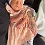 Pennie-Mae is registered to the contest to win money with this photo: newborn, baby, sleeping, infant, dress, headband, tattoo, arm, couch, blanket, white_socks, peaceful, closeup, indoors, person, human, soft_light, relaxing, cute, resting
